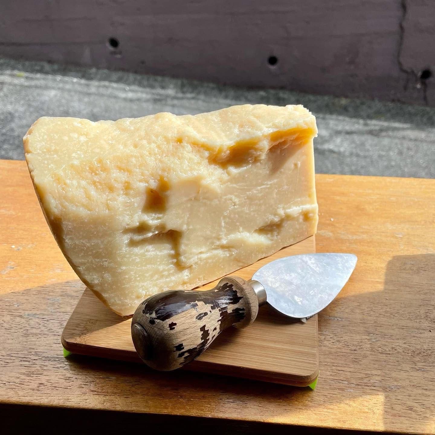 Wedge of 24-month aged Parmigiano Reggiano with a rustic cheese knife