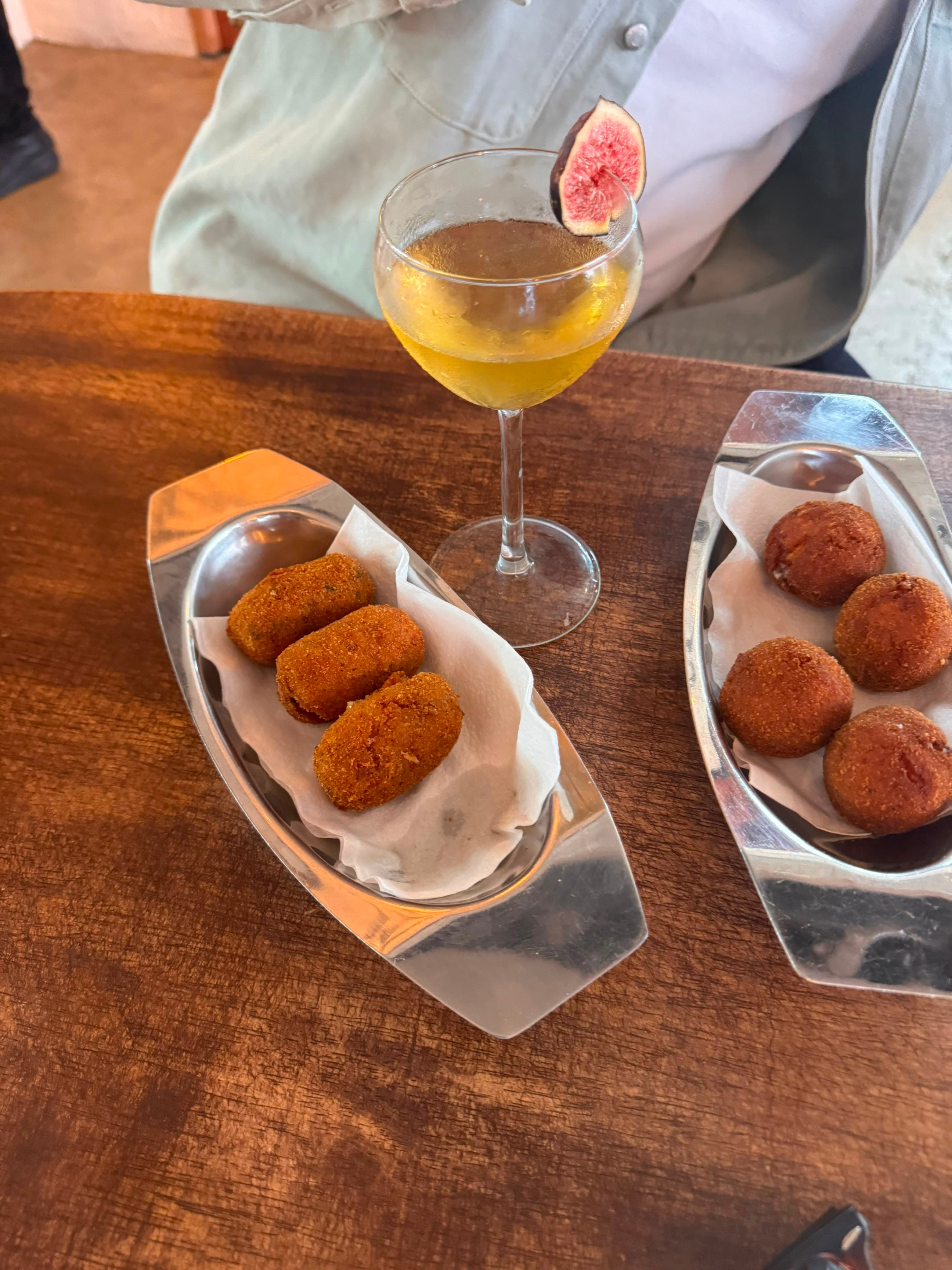 Crispy suppli served in silver dishes with a fig cocktail