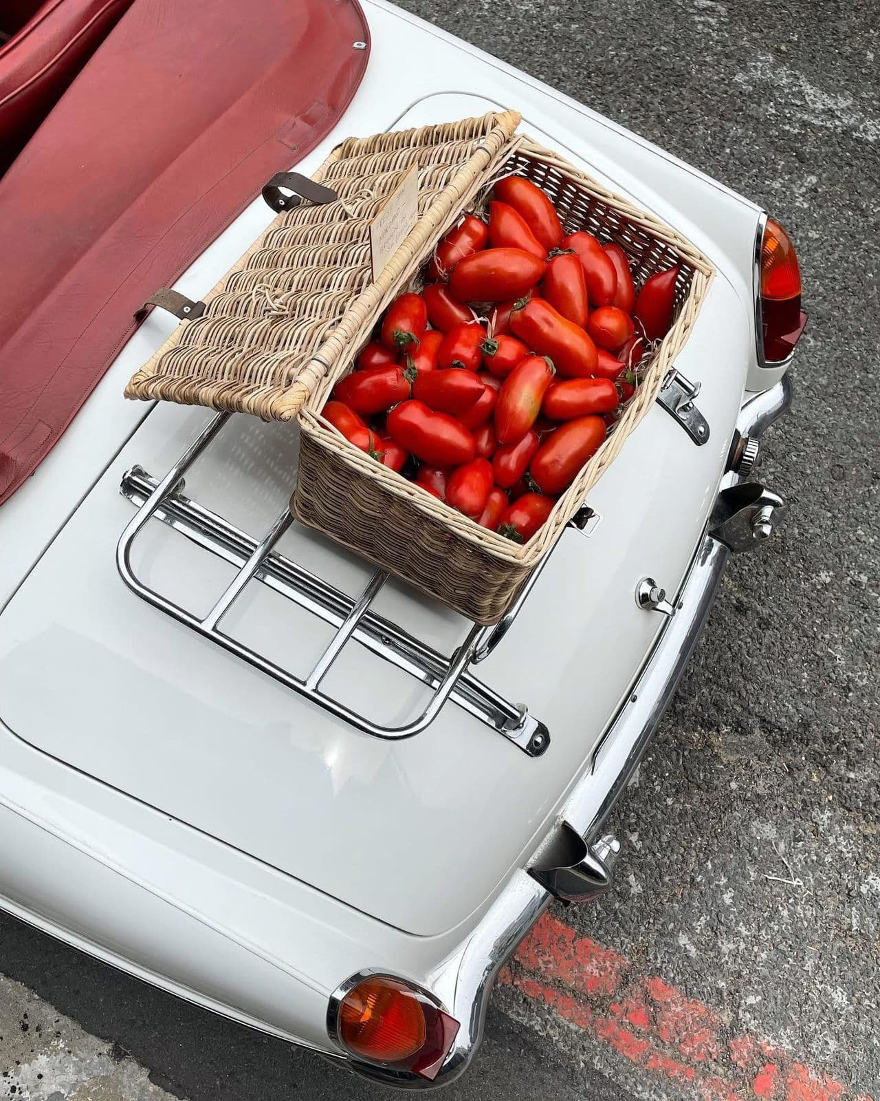 Basket of San Marzano tomatoes on a classic Vespa luggage rack