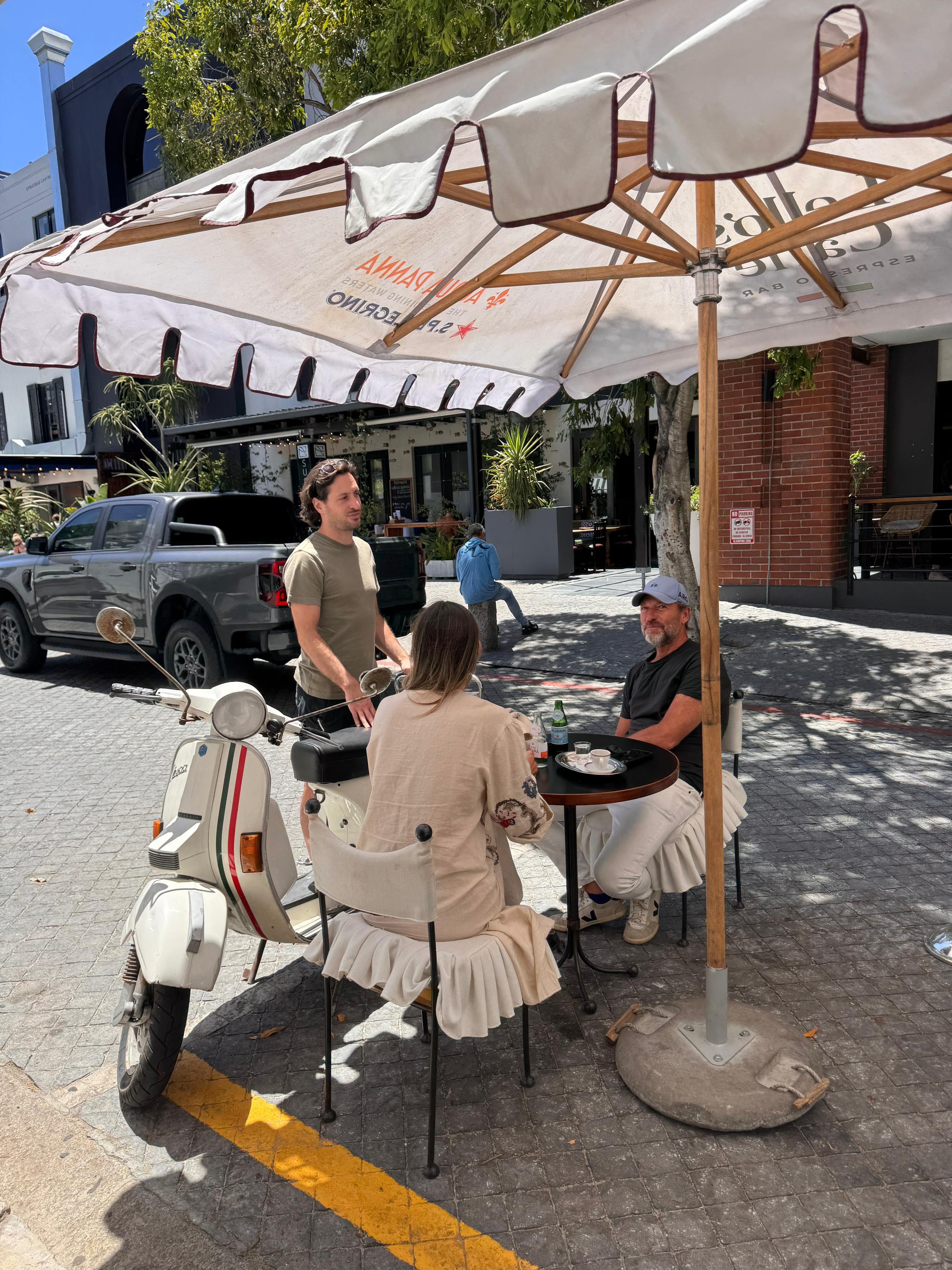 Lello's Caffé outdoor tables in De Waterkant with a classic Vespa parked outside
