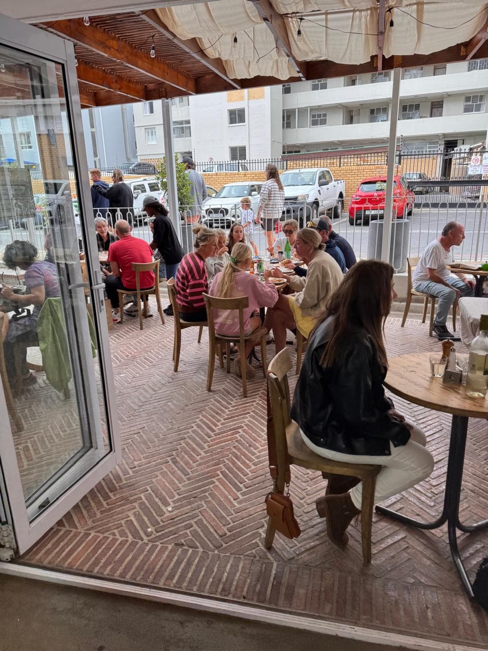 Guests dining at Lello's Trattoria outdoor terrace with herringbone brick floor